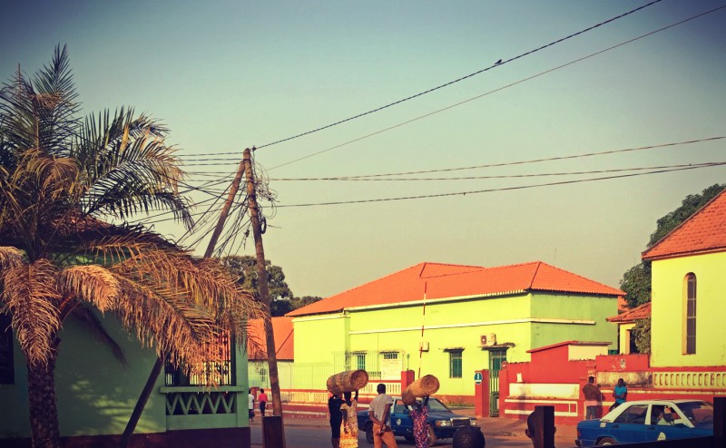 Une rue de Bissau, des bâtiments verts et des personnes #Off2África 50 Bissau Guinée-Bissao © Gilles Denizot 2017
