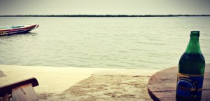 La tradition de la bière Gazelle à l'arrivée dans un nouveau lieu. Ici, une Gazelle, pieds dans le sable face à l'horizon du fleuve Casamance #Off2Africa 45 Ziguinchor Casamance Sénégal © Gilles Denizot 2017