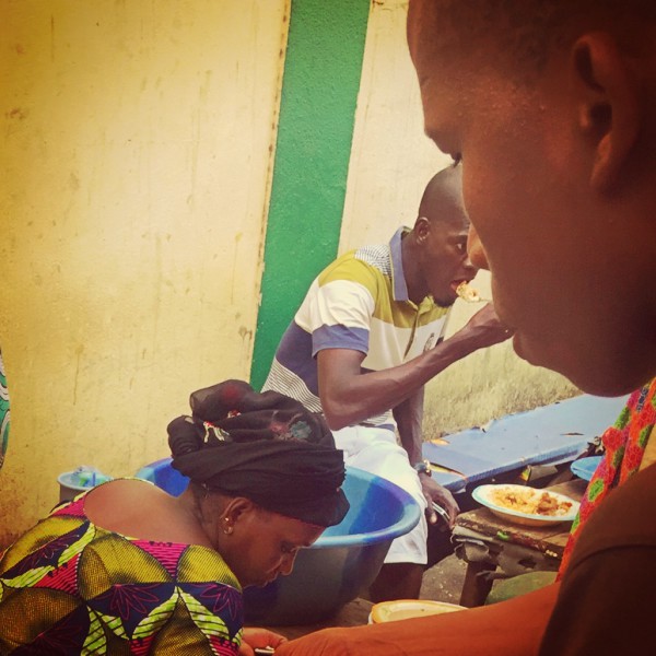 Un homme mange de la nourriture préparée par des femmes au maquis du coin #Off2Africa 66 Conakry Guinée © Gilles Denizot 2017