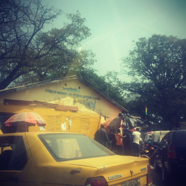 Voiture jaune, maison jaune, deux parasols et des gens #Off2Africa 64 Conakry Guinée © Gilles Denizot 2017