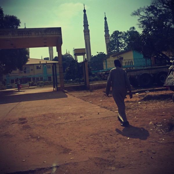 Un homme marchant en direction d'une mosquée #Off2Africa 70 Conakry Guinée © Gilles Denizot 2017