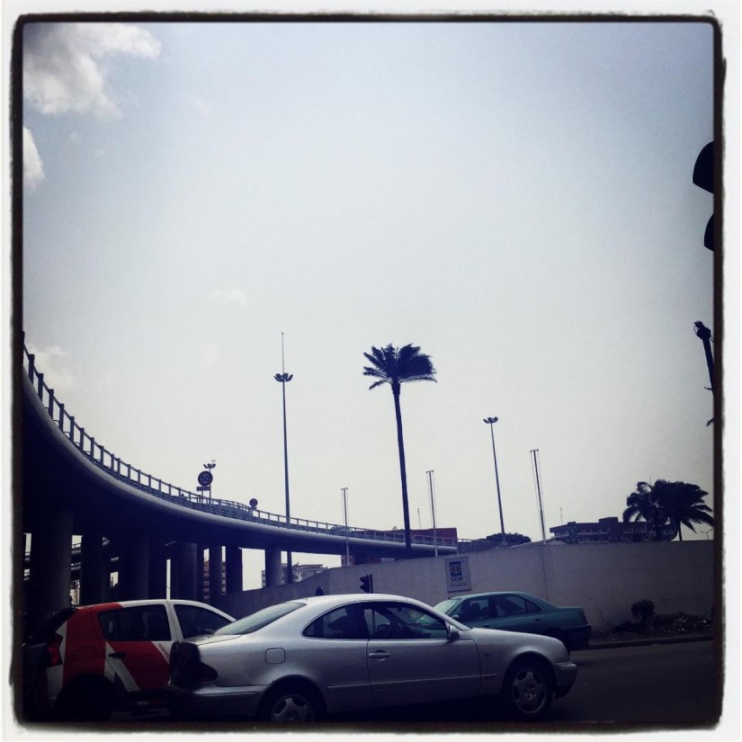 Unique palmier dans la jungle de béton d'Abdijan, un bras de route élevé surplombe les voitures en contrebas #Off2Africa 94 Abidjan Côte d'Ivoire © Gilles Denizot 2017
