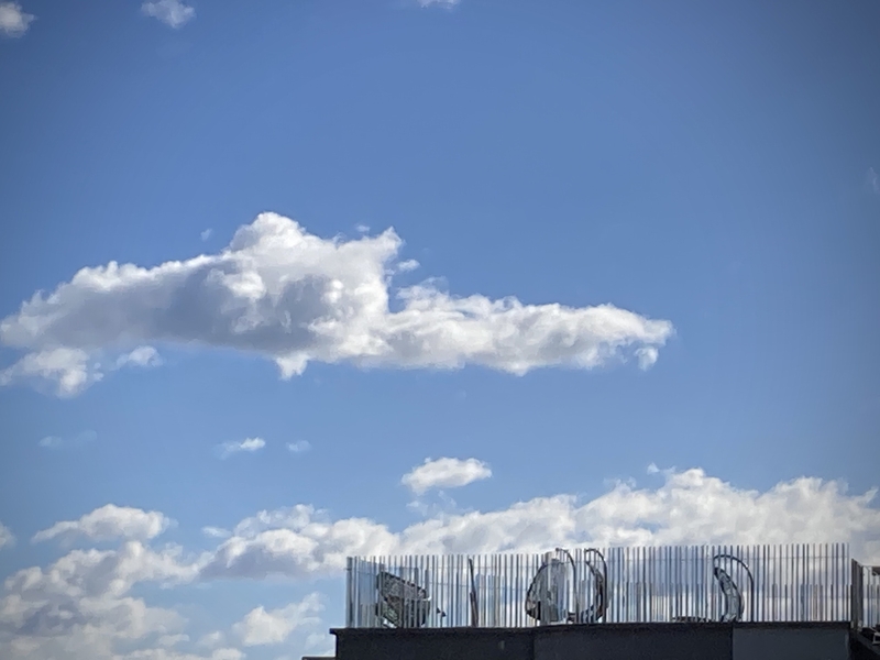 Le ciel bleu de Barcelone, quelques nuages et une rangée de siêges vides suspendus dans l'air © Gilles Denizot 2023