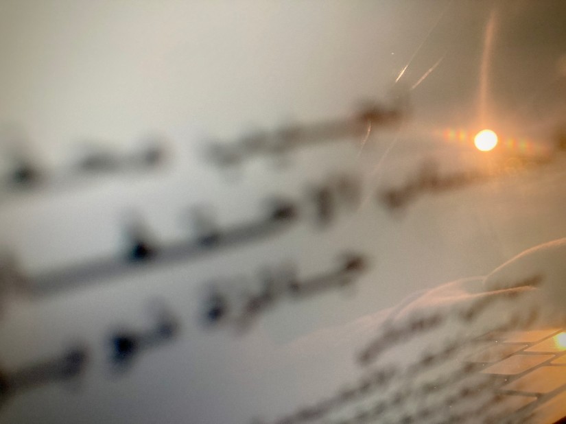 Texte flou en arabe sur un écran d'ordinateur sur lequel se projette de la lumière #HolaBCN Le vieux quartier © Gilles Denizot 2024