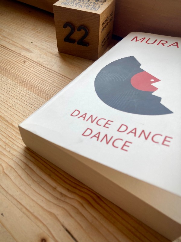 Couverture du livre Dance Dance Dance de Murakami posé sur du bois à côté d'un cube en bois marqué 22 #HolaBCN Rothko du matin © Gilles Denizot 2024