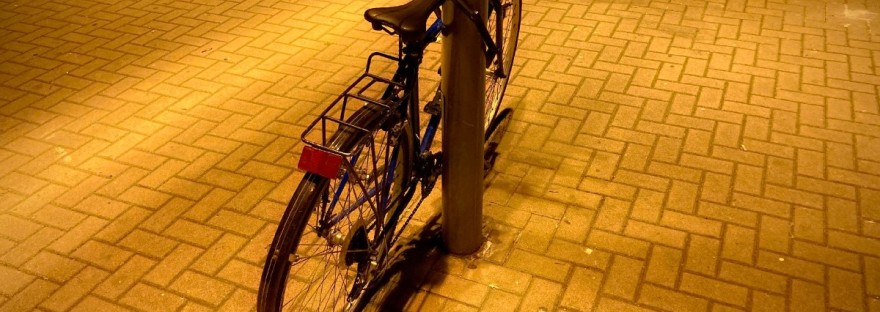 Un vélo appuyé contre un réverbère, lumière jaune sur les pavés #HolaBarcelona février 2023 © Gilles Denizot